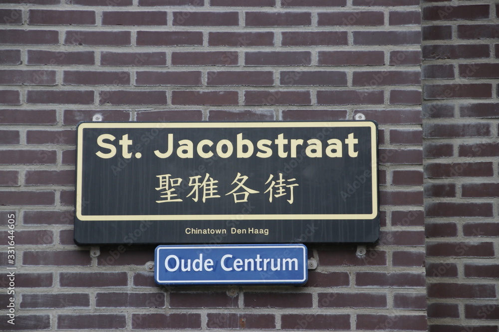 Street name sign St. Jacobsstraat in Dutch and Chinese in Chinatown in the Hague Street name sign St. Jacobsstraat in Dutch and Chinese in Chinatown in the Hague