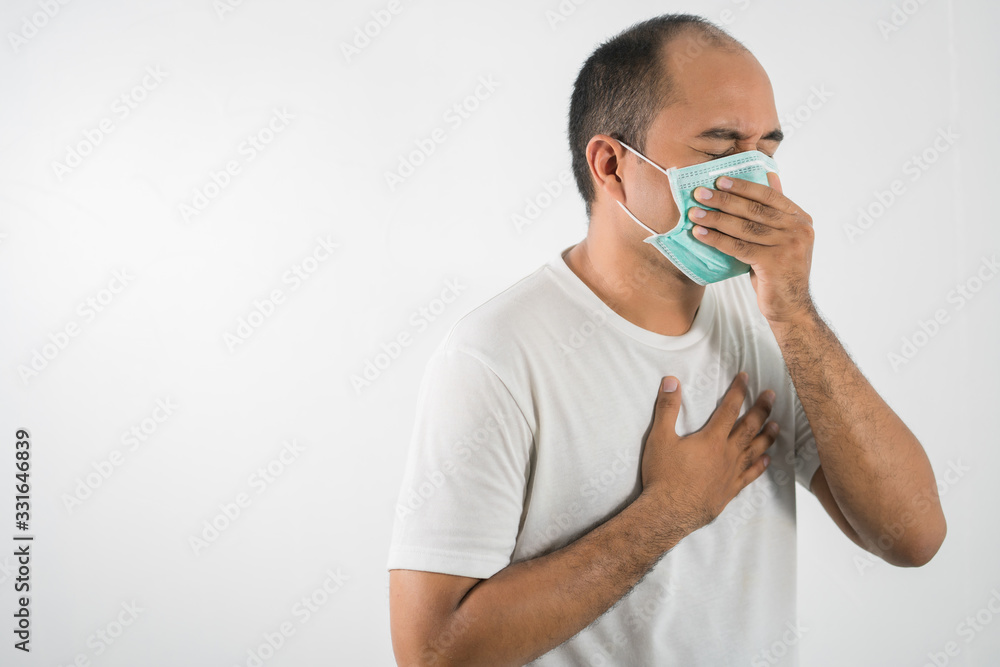 The young man had a cold and a fever. He wearing protection mask. coronavirus or covid 19 concept. The young man had a cold and a fever. He wearing protection mask. coronavirus or covid 19 concept.
