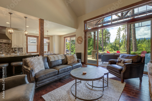 An absolute beautiful luxury living room with huge vaulted ceiling, fire place, harwood floor, amazing furniture, and lots of windows and doors.