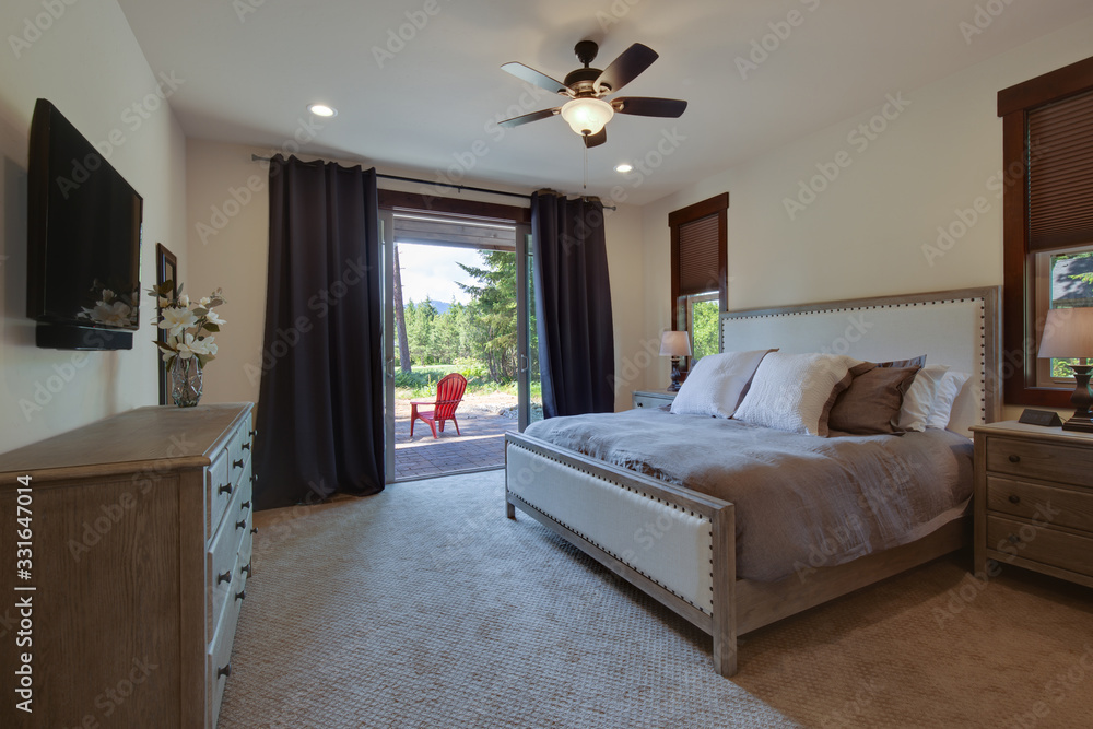 Beautiful large luxury new bedroom with great design, beige, grey and white tones, TV bove dresser, rich wooden doors, window blinds and grey carpet. Cozy and practicle. Expensive furniture.