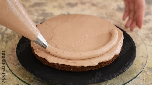 Pastry Chef Making A Cake On The Kitchen. Female Hand Squeezes The Chocolate Cream.