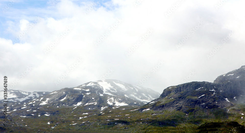 Snowy mountains and blue cold sky at Norwegian fjord coast