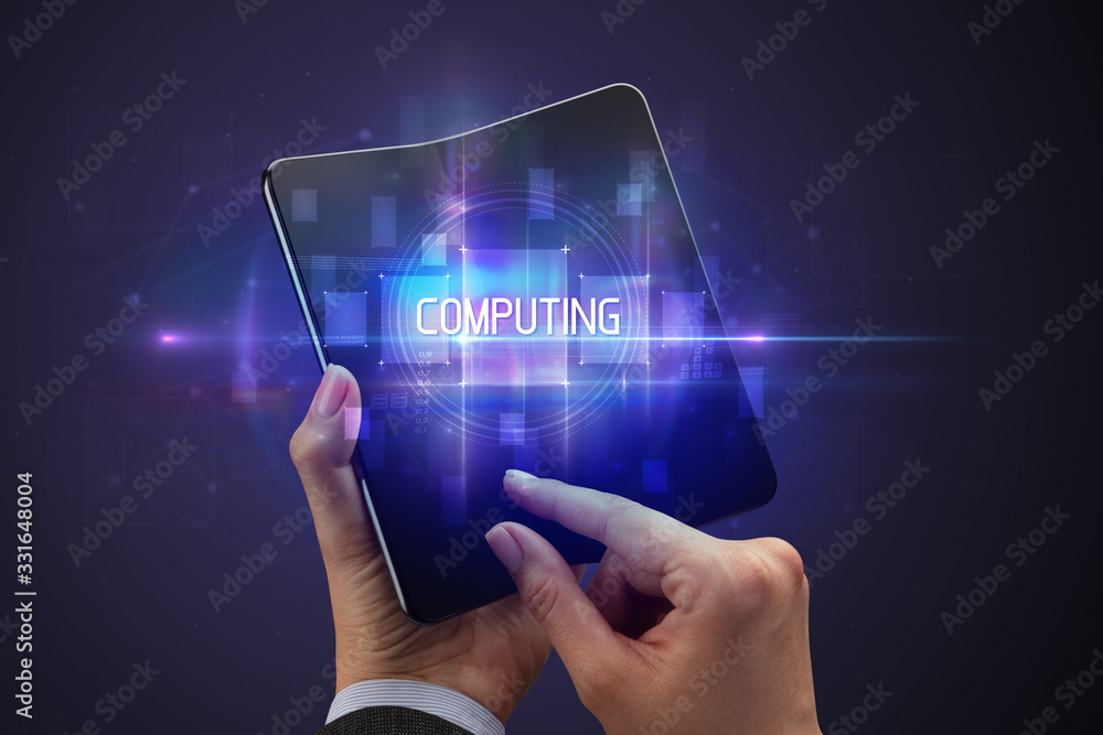 Obraz premium Businessman holding a foldable smartphone with COMPUTING inscription, new technology concept