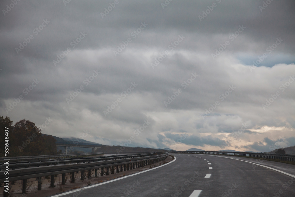 Gray smooth asphalt road in mountains turning left