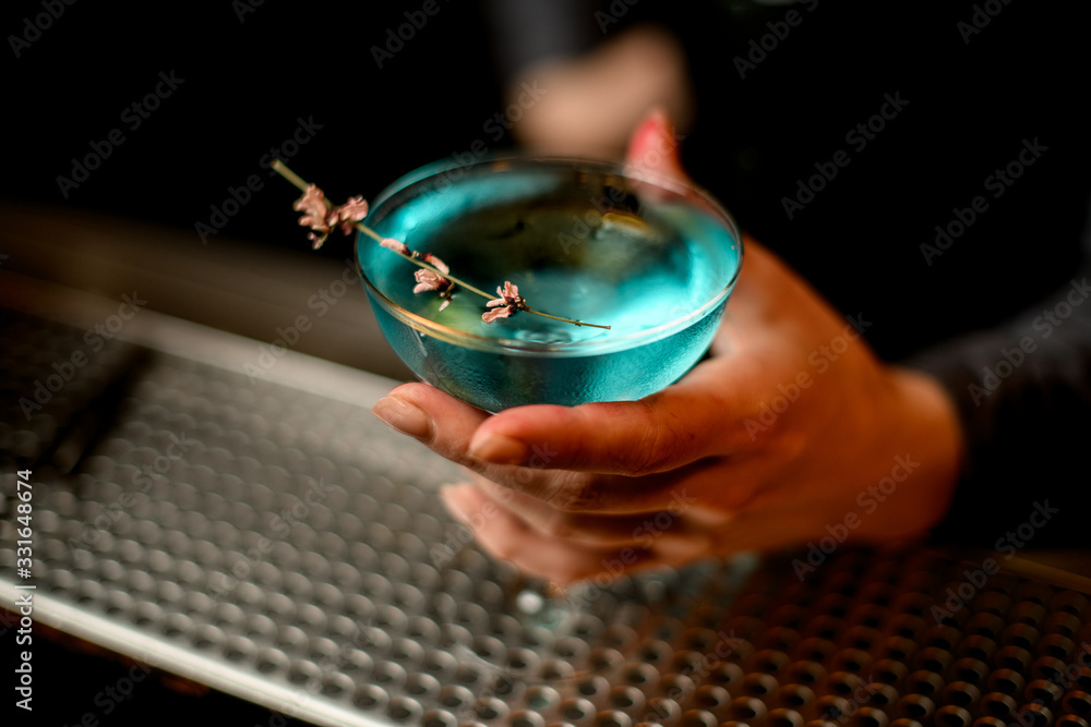 close-up glass with blue cocktail stands on bar counter - obrazy, fototapety, plakaty 