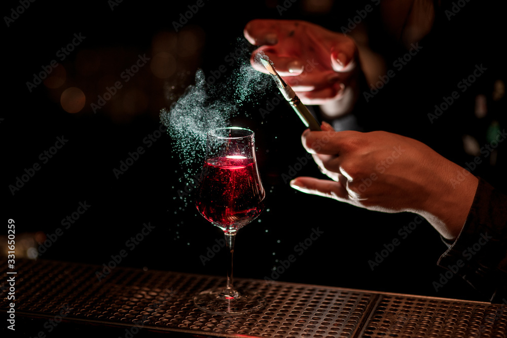 barman's hand professionally decorates alcoholic cocktail with colored powder using brush. - obrazy, fototapety, plakaty 