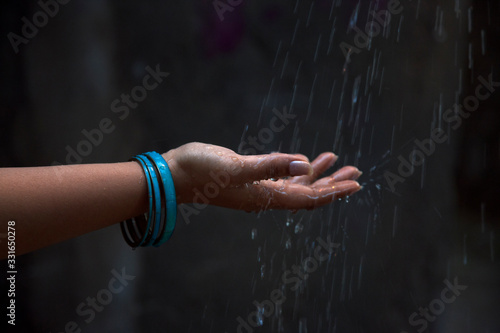 Woman with bangles enjoying rain in outdoor 