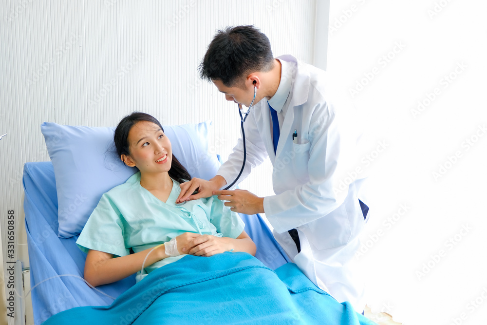 Fototapeta premium Young male Asian doctor physician listening to action patient lie in bed heartbeat or breathing patients in the hospital/ Healthcare and medically concept.