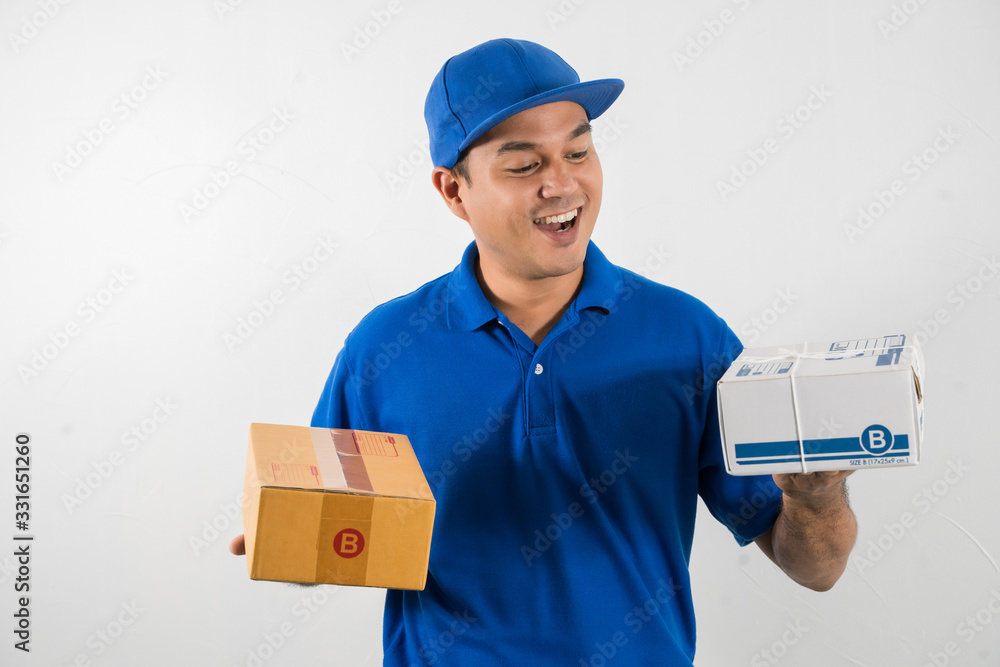 Blue Delivery handsome asian man holding parcel cardboard box on isolated white background. Blue Delivery handsome asian man holding parcel cardboard box on isolated white background.