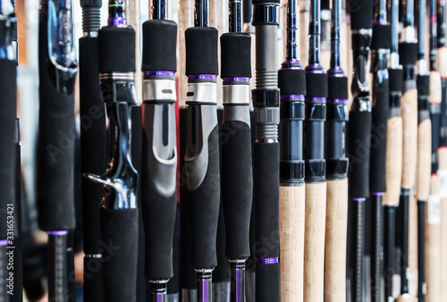 different rods and spinning rods for fishing on the counter in the store. Shallow depth of field