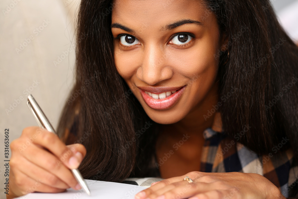 Smiling black woman write story in notebook preparing for college Smiling black woman write story in notebook preparing for college