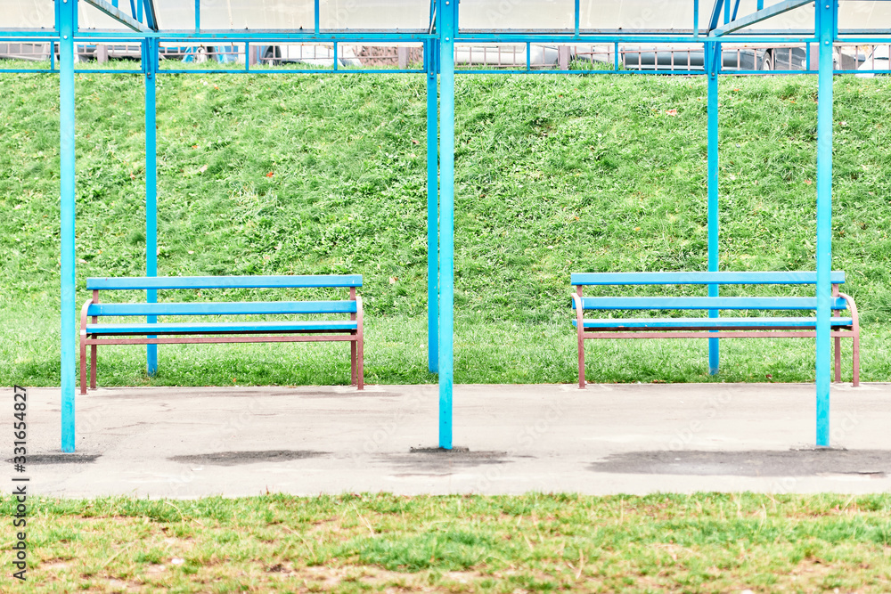 two empty benches under a canopy.