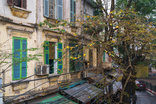 Yellow leaves with old house exterior in old town of Hanoi