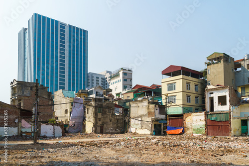 Ruin houses on highrise building background contrast on Minh Khai street, Hanoi, Vietnam