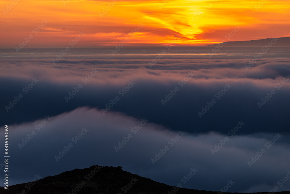  Dreamy misty landscape above the sea of clouds, mountains at sunset in Iceland