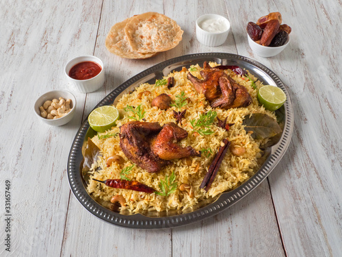 Chicken Mandi with dates on a wooden table. Arabic cuisine.
