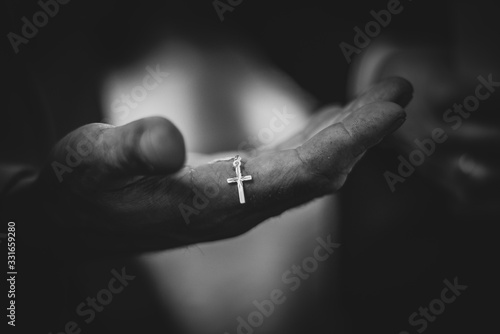 A man holding a small cross in his hand.