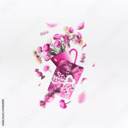Greeting concept. Pink composition with flying present and gift , cup of flowers bunch and heart on white background Mothers day, birthday .