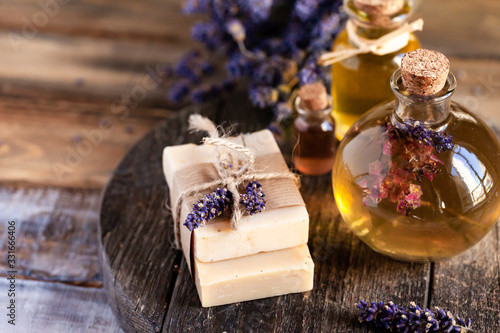 Concept of natural organic oil in cosmetology. Moisturizing skin care and aromatherapy. Gentle body treatment. Handmade soap. Atmosphere of harmony relax. Wooden background, lavender flower copy space