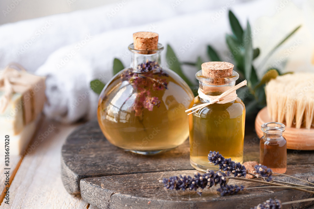 Concept of natural organic oil in cosmetology. Moisturizing skin care and aromatherapy. Gentle body treatment. Handmade soap. Atmosphere of harmony, relax. Wooden background, lavender flowers - obrazy, fototapety, plakaty 