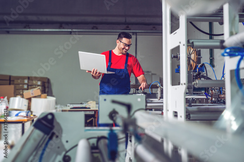 Industrial engineer with laptop in a industrial manufacture factory working.