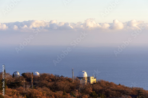 white domes of telescopes at the Simeiz observatory on the background of the sea