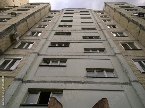 Symmetric facade of old soviet multistorey typical concrete apartment.