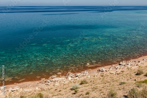 clear water in Issyk-Kul Lake in Kyrgyzstan  stones under water at the bottom.