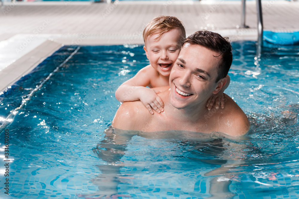 happy toddler kid and swim coach smiling in swimming pool happy toddler kid and swim coach smiling in swimming pool