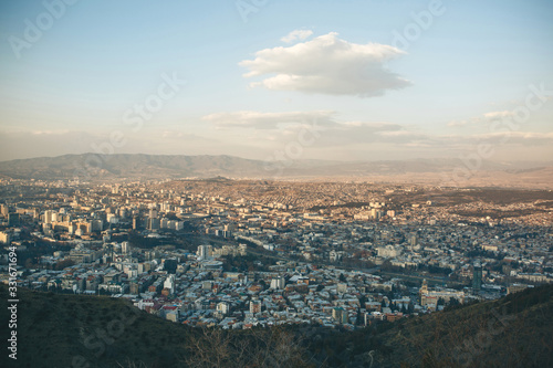 Beautiful panoramic view of Tbilisi, Georgia. The city near the mountains against the sky with clouds. © franz12