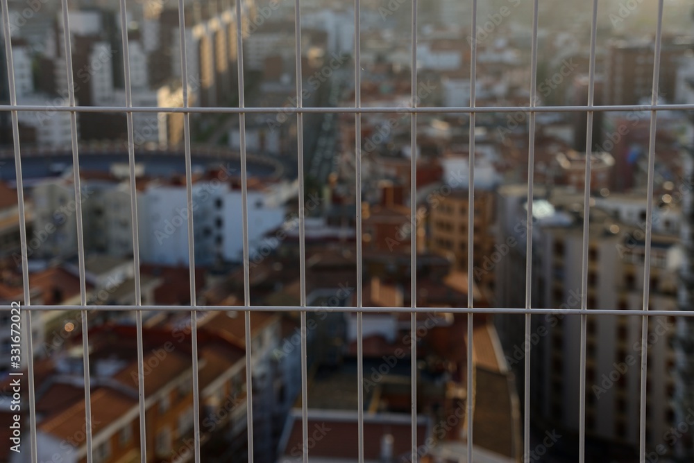 Cityscape at sunset with steel fence