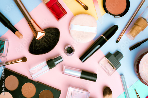 Makeup products and cosmetics on multi color background, flat lay. Fashion and beauty blogging concept. Top view