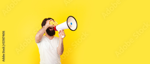 positive bearded man with megaphone over yellow background, concept of summer mood, panoramic mock-up with space for text