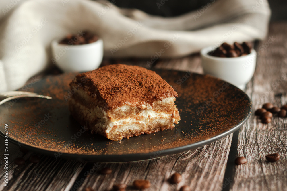 Tiramisu cake on a plate. Romantic composition with coffee and other elements