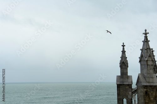 Pináculos de una iglesia, el mar y una gaviota