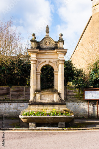 The C.T. Mayo memorial fountain and drinking trough with a pedestal and open moulded arch situated in Corsham High Street Wiltshire photo