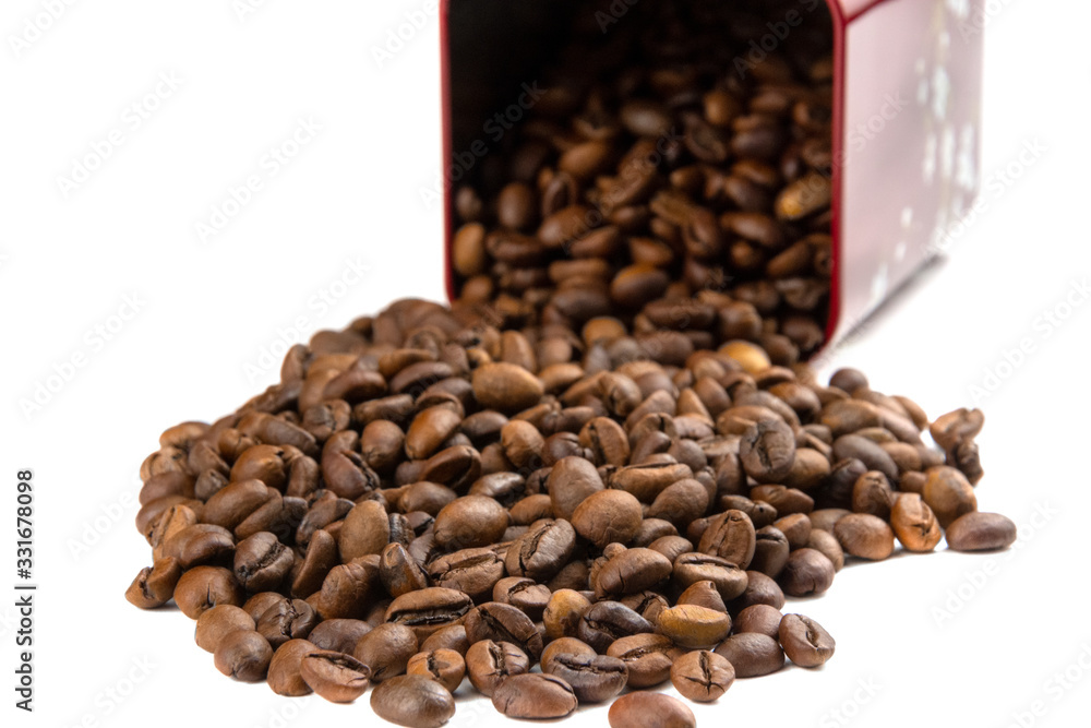 Roasted coffee beans spilling out of a metal box isolated on a white background