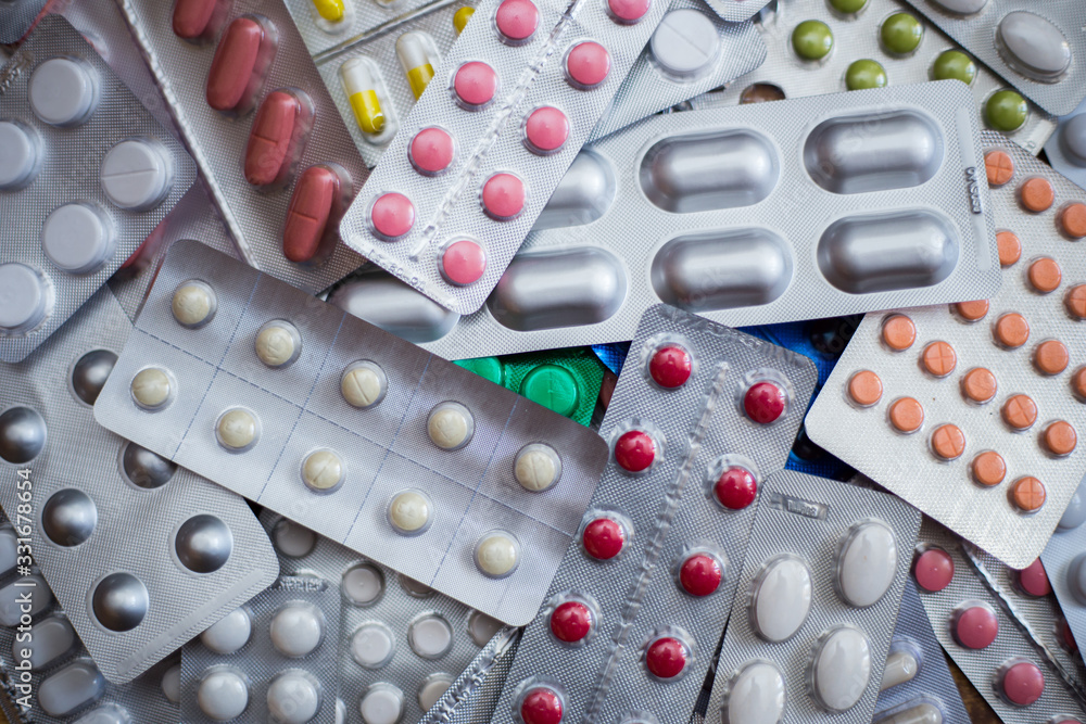 A pile of multi-colored pills lie one on one A pile of multi-colored pills lie one on one