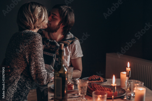 young couple having dinner at home by candlelight