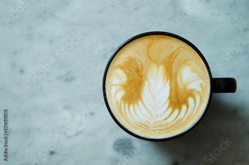 Fototapeta Latte in black cup on stone background 