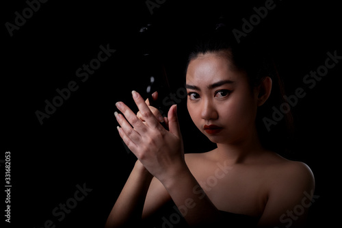 Portrait beautiful asia woman hand holding a pistol gun at black background, Young sexy girl long hair with a handgun look at the camera, Pretty women stands with a pistol photo