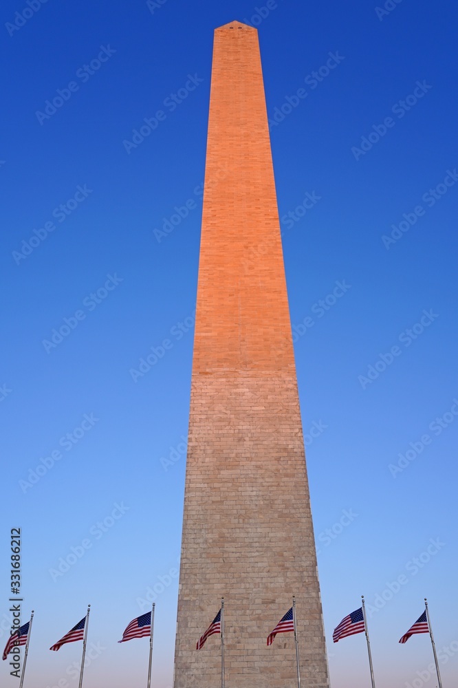 View of the landmark Washington Monument obelisk in Washington, DC with an American flag