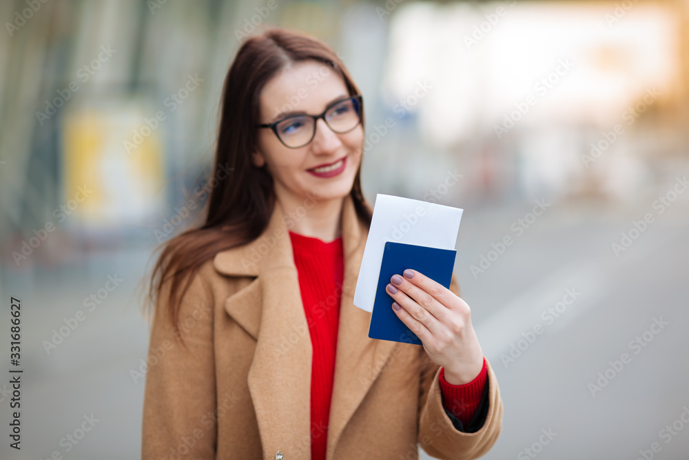girl holds a passport near the airport