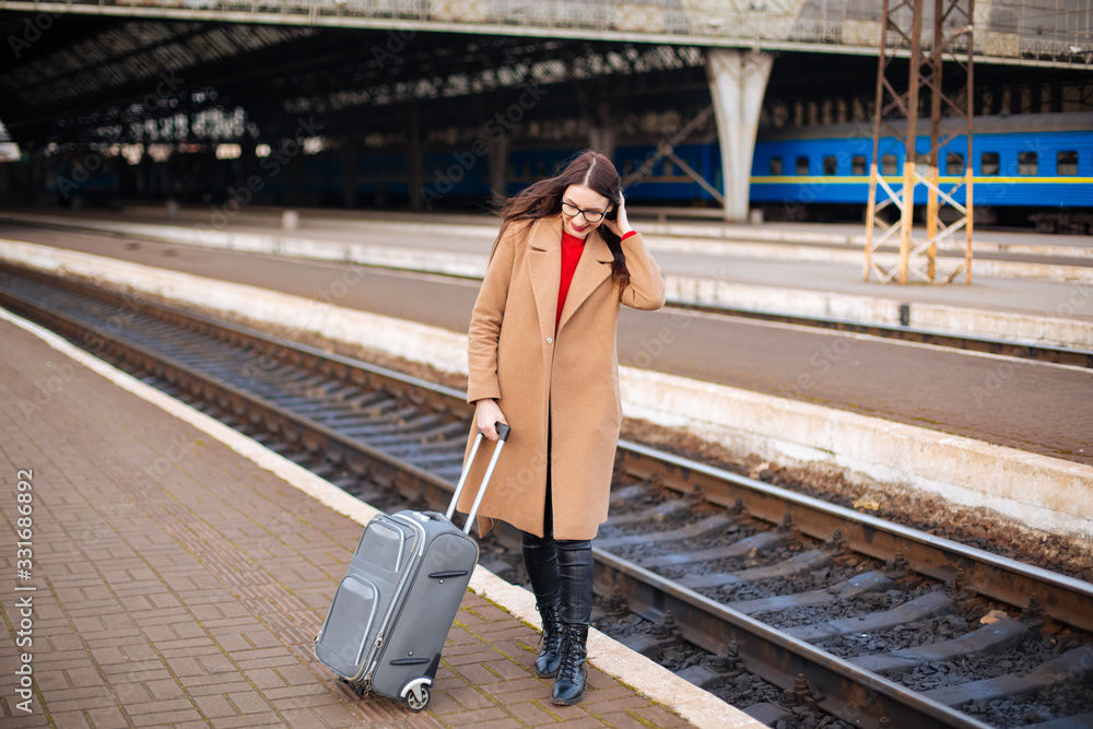 girl in a coat with a suitcase going to the landing zone
