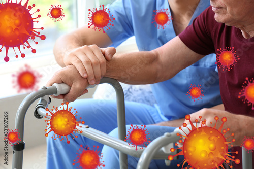 Elderly man with caregiver in nursing home. Concept of Coronavirus epidemic photo