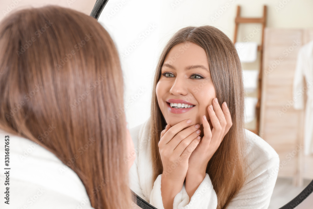 Beautiful young woman with healthy skin looking in mirror Beautiful young woman with healthy skin looking in mirror