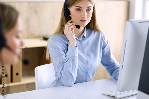 Portrait of call center operator at work. Group of people in a headset ready to help customers. Business concept