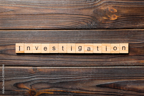 investigation word written on wood block. investigation text on table, concept
