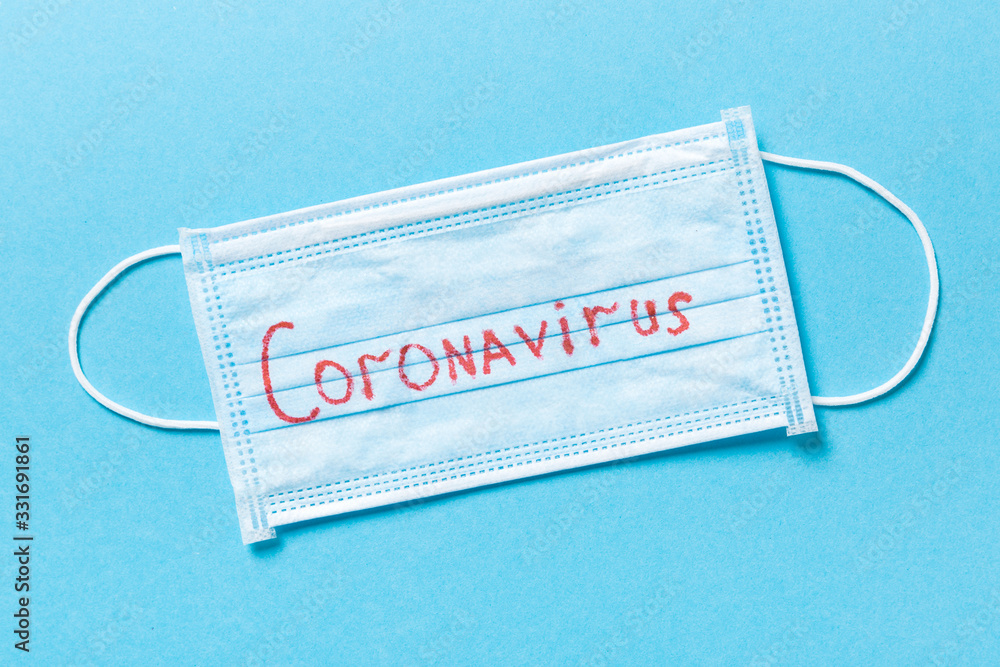 Blue novel disease background made of protective medical masks. Top view of coronavirus word. Global epidemic concept Blue novel disease background made of protective medical masks. Top view of coronavirus word. Global epidemic concept