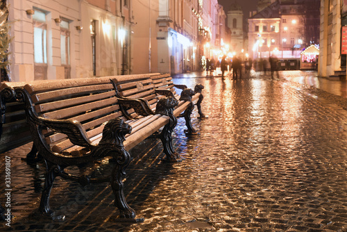 wooden bench on rainy street of old city